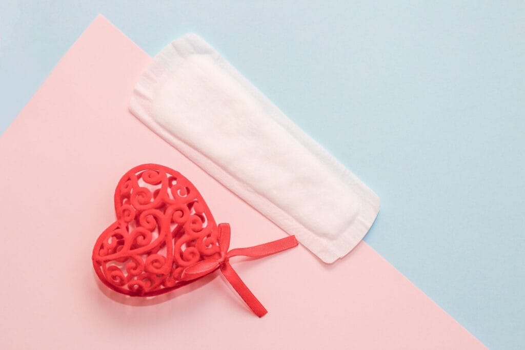 Menstrual sanitary napkin supplies with a red heart on a paper background